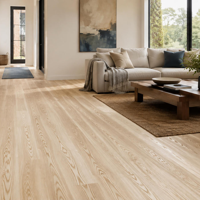 Light-toned ash hardwood flooring in a bright modern living room with natural grain and a clean contemporary interior