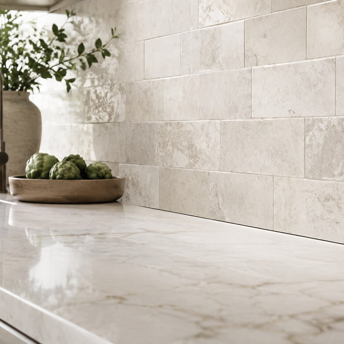 Modern kitchen backsplash tile above a stone countertop with a clean sealed transition gap.