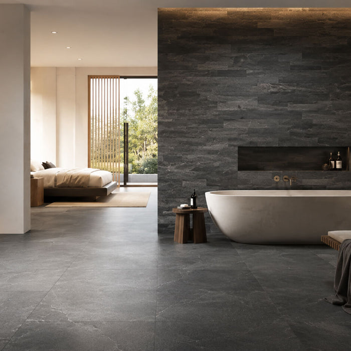 Modern interior featuring dark basalt tile flooring and a textured basalt feature wall with warm wood accents