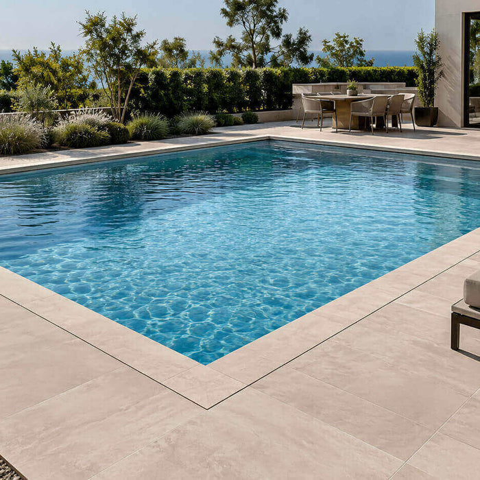 Modern rectangular pool with clean light stone coping, precise corners, and coordinated pool deck