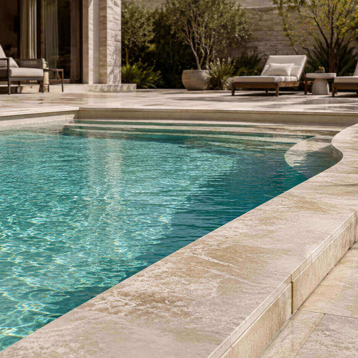 Light natural stone coping around a modern saltwater pool with a textured pool deck and turquoise water