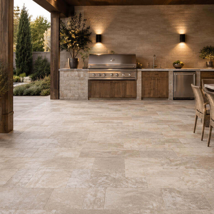 Covered outdoor kitchen with premium stone flooring, built-in grill, dining area, and poolside setting
