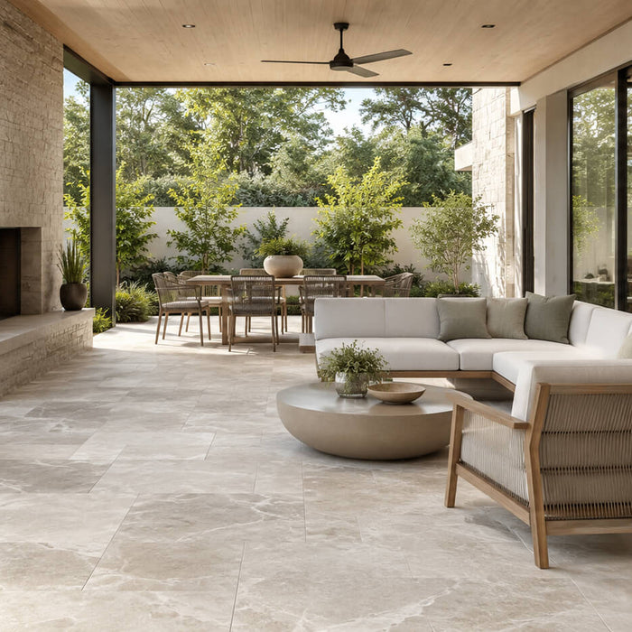 Covered patio with neutral tile flooring, natural stone walls, outdoor seating, and a seamless indoor-outdoor design