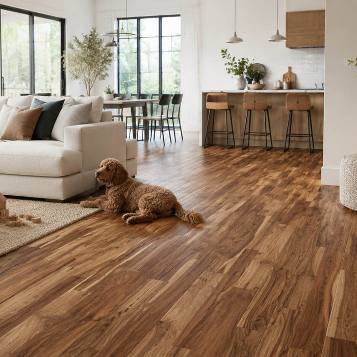 Bright modern family living room with acacia hardwood flooring, a neutral sofa, kids toys, and a dog resting on the floor.