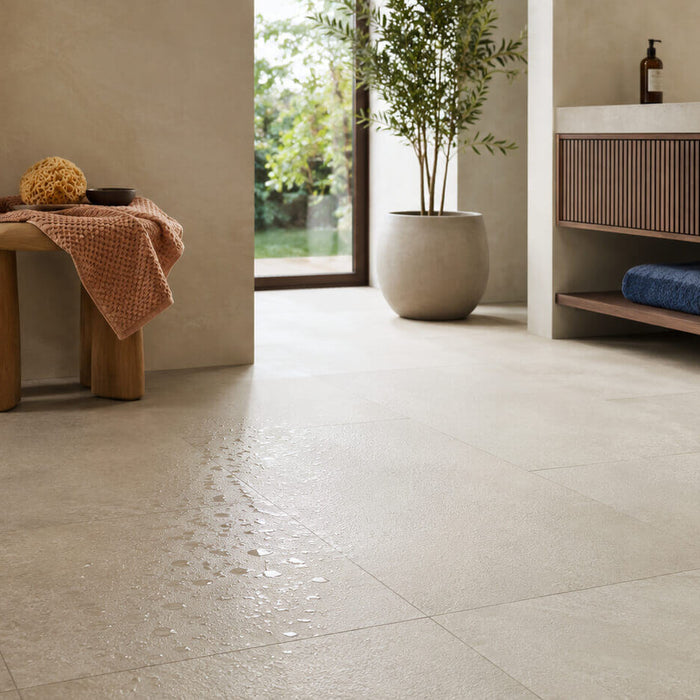 Modern bathroom with light beige porcelain tile flooring and visible water droplets, illustrating wet-floor slip conditions for porcelain tile.