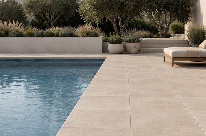 Minimalist pool edge design with light stone coping, large-format pavers, aligned joints, and modern landscaping