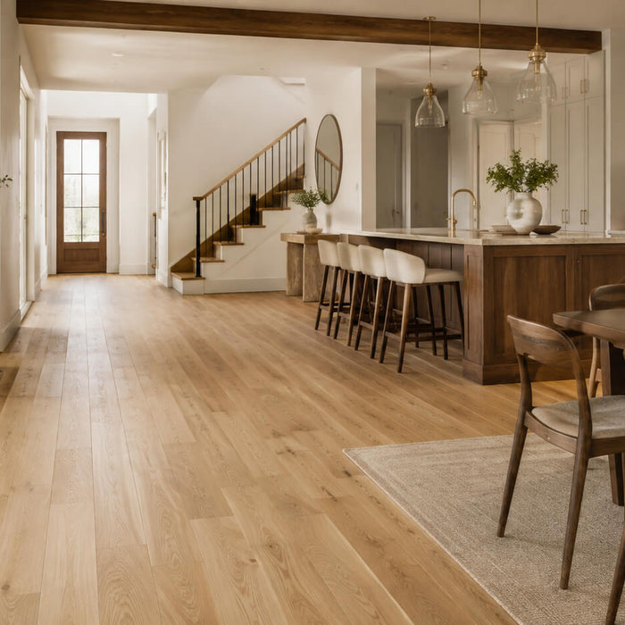Open-plan home interior with light oak flooring, darker wood kitchen island and dining furniture showing how mixed hardwood tones can work together in one home.