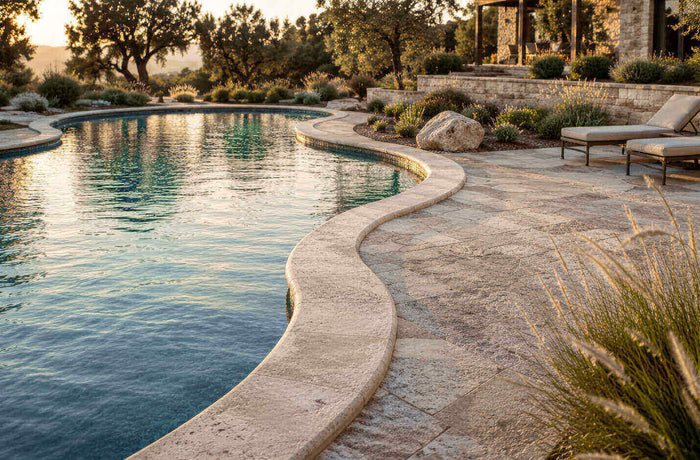 Freeform swimming pool with curved natural stone coping and coordinated stone pool deck