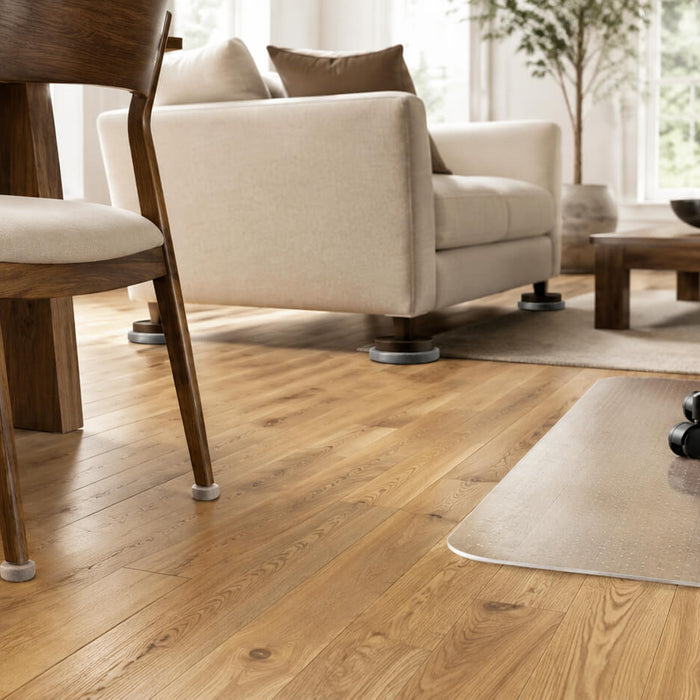 Furniture legs protected with felt pads, furniture cups, and a chair mat on hardwood flooring