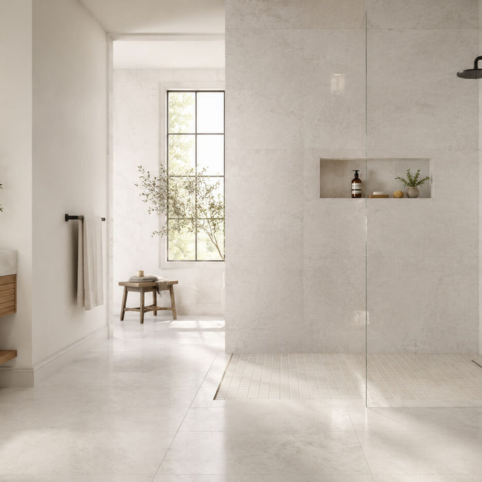 Modern bathroom using the same light tile on the bathroom floor and shower walls