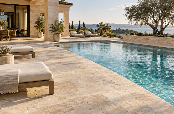 Luxury outdoor pool surrounded by light travertine pavers and matching pool coping