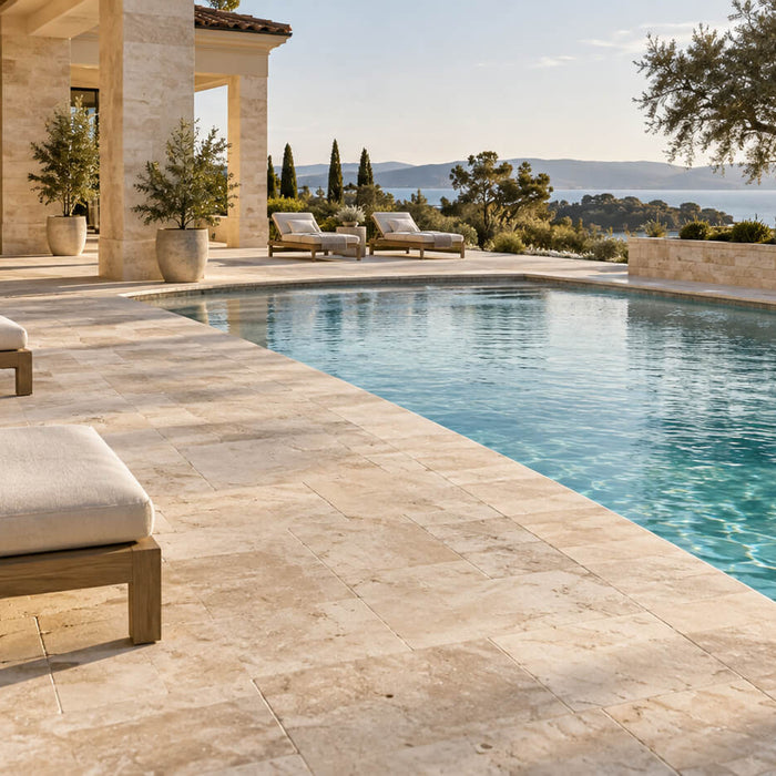 Luxury outdoor pool surrounded by light travertine pavers and matching pool coping