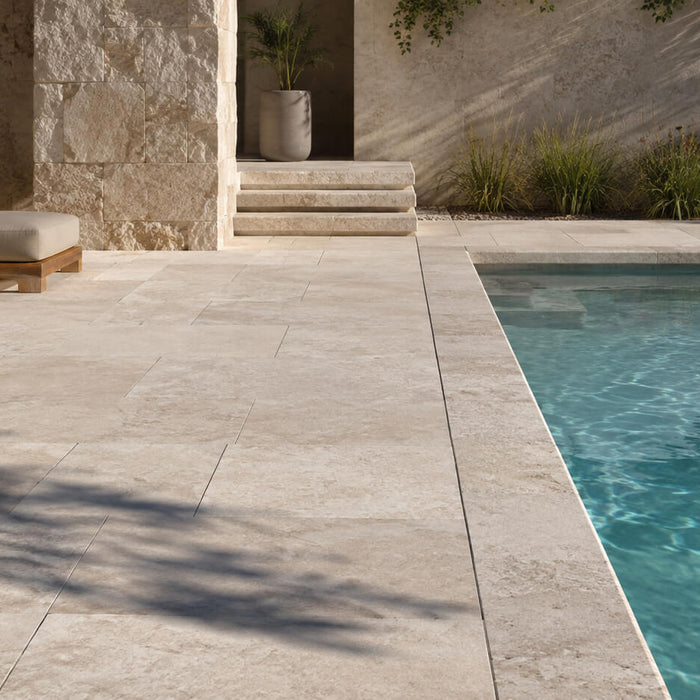 Sunlit natural stone patio and pool coping showing outdoor stone exposed to direct sunlight and shade
