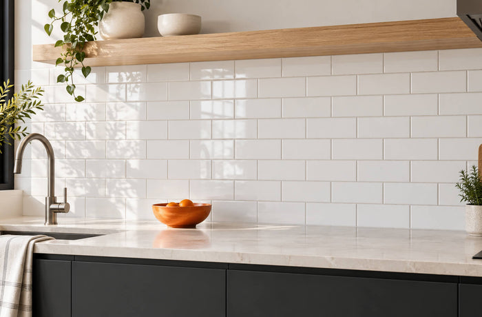White subway tile backsplash with charcoal cabinets, an oak shelf, and a light stone countertop.
