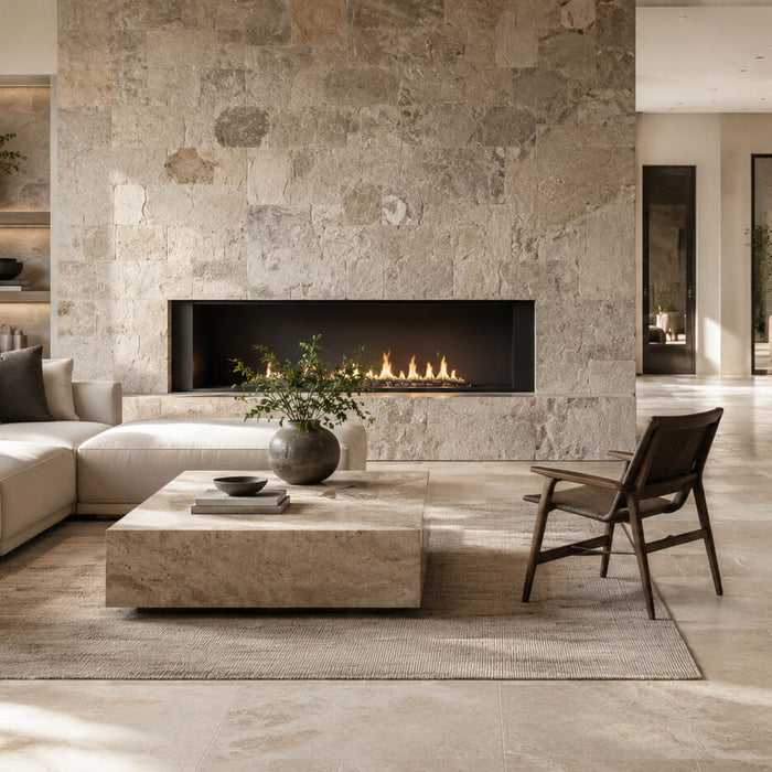 Elegant modern living room with natural stone flooring and a large stone fireplace wall, showing how natural stone adds warmth, texture, and timeless value to interior design.