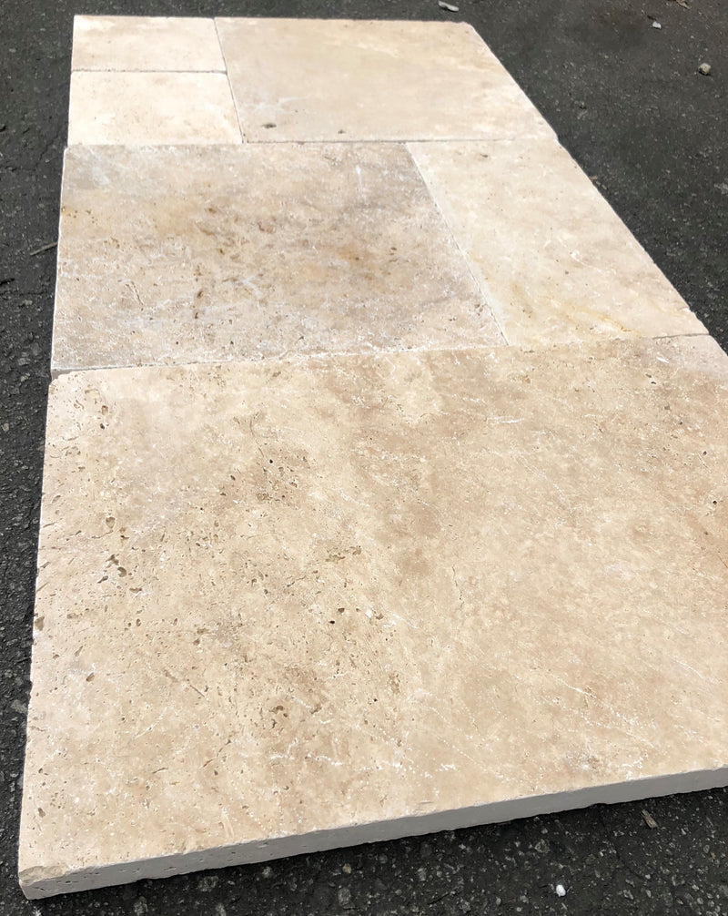 Close-up of Ivory Cordoba Cream Travertine Unfilled, Brushed & Chiseled French Versailles x 1/2 Cross Cut Tile, in Ivory tones.