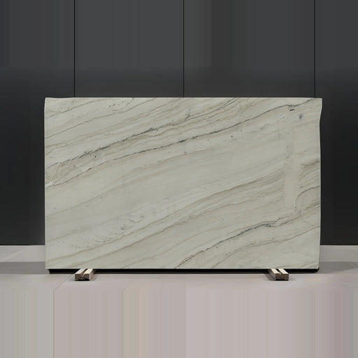 Full view of a Bellagio 3cm polished quartzite slab with a warm white surface, fine diagonal gray and beige veining, and a few darker mineral lines.