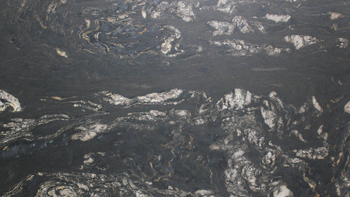 Close-up of Black Cosmic leathered granite with dark gray, silver and subtle gold veining.