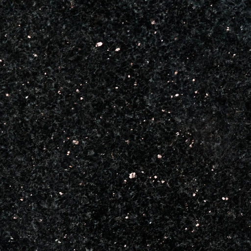 Close-up of Black Galaxy 12x24 polished granite tile with a deep black surface and scattered bronze and silver mineral flecks.
