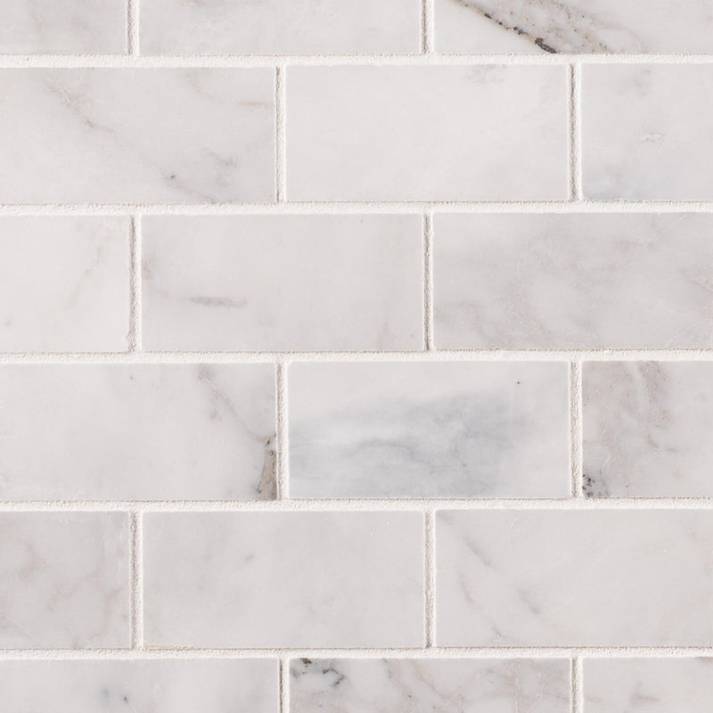 Calacatta Cressa 2x4 honed marble subway mosaic tile with gray and beige veining in a staggered brick pattern.
