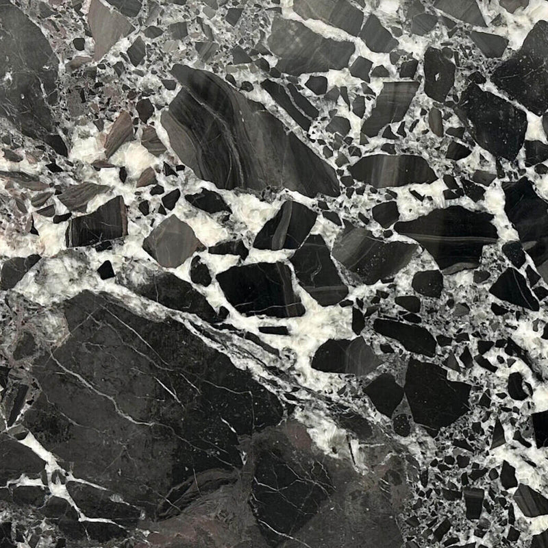 Constantine Black polished marble surface with large black and charcoal fragments separated by irregular white and cream mineral veins.