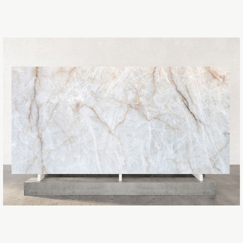 Cristallo quartzite slab with a translucent white surface and delicate beige and gray veining, displayed on a stand.
