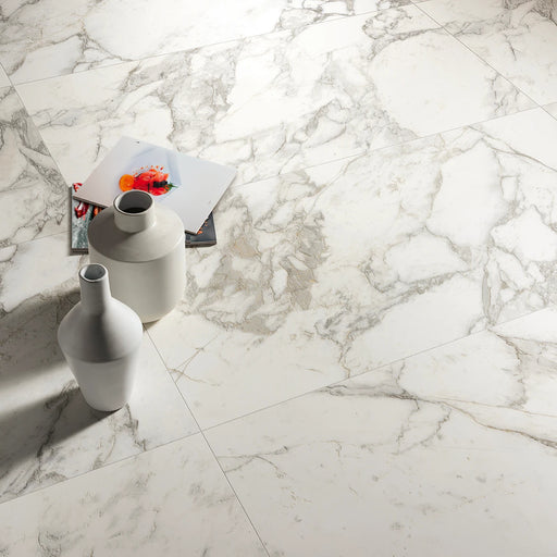 Edimax Symphony Moon 24x48 matte porcelain tile flooring with marble-look veining beside two white decorative vases.