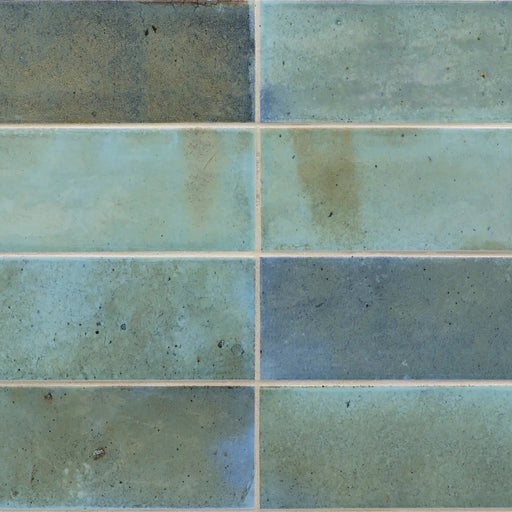 Equipe Hanoi Sky Blue 2x6 glossy ceramic tiles with varied blue-green tones, mottled surfaces and a stacked horizontal layout.