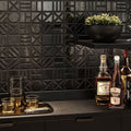 Forma Black geometric relief ceramic wall tiles installed behind a bar countertop.