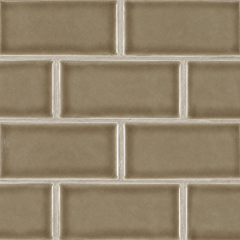 Glossy taupe 3x6 ceramic subway tiles with subtle crackle texture in a staggered pattern.