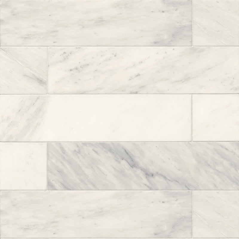London Calling Cloudy 24x6 honed marble tiles with soft ivory-white tones and delicate gray veining in a staggered horizontal layout.
