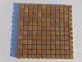 Close-up of Noce Toros Travertine Tumbled 1 x 1 Mosaic, in Noce tones.