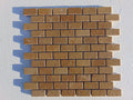 Close-up of Noce Toros Travertine Split Face 1 x 2 Mosaic, in Noce tones.