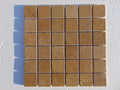 Close-up of Noce Toros Travertine Tumbled 2 x 2 Mosaic, in Noce tones.