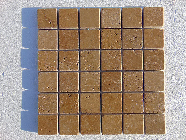 Close-up of Noce Toros Travertine Tumbled 2 x 2 Mosaic, in Noce tones.