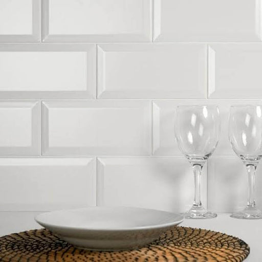 Metro Blanco Mate 15 3x5.9 matte white ceramic tiles with beveled edges installed in a staggered pattern behind tableware.