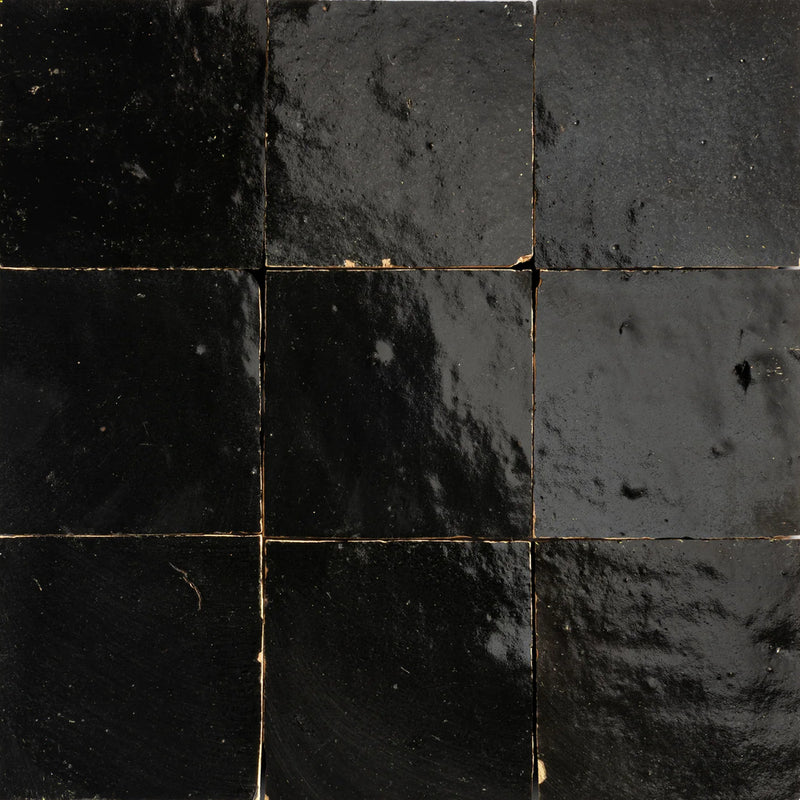 Black Moroccan Zellige ceramic wall tiles with varied glossy surfaces and subtle handmade edges.