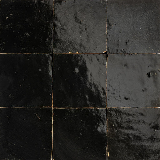 Black Moroccan Zellige ceramic wall tiles with varied glossy surfaces and subtle handmade edges.