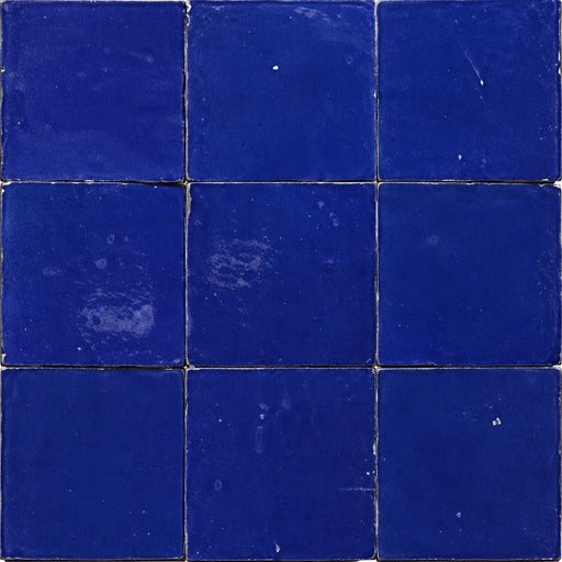 Moroccan Zellige Blue 4x4 ceramic wall tiles in a three-by-three layout with deep cobalt-blue tones and irregular edges.