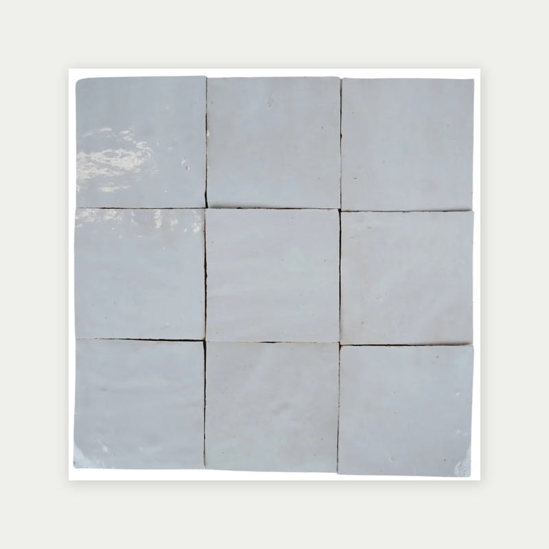Nine Moroccan Zellige white ceramic wall tiles showing subtle shade variation and handmade edges.
