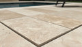 Close-up of Ivory Cordoba Cream Travertine Tumbled 16 x 24 x 2 Double Modern Coping, in Ivory tones.