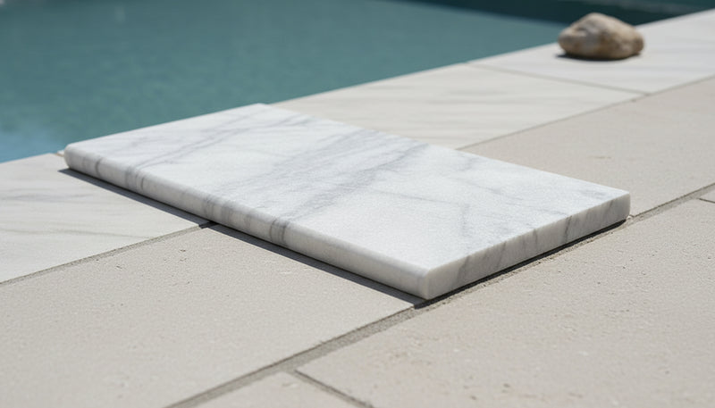 Close-up of Natural Carrara Equinox Marble Leather (Sandblasted & Brushed) 12 x 24 x 2 Double Modern Coping, in Natural tones.