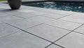 Close-up of Indian Black Limestone Tumbled & Brushed 16 x 24 x 2 Modern Coping, in Black tones.