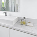 Pietra Danali Danae polished quartz bathroom countertop and backsplash with a white vessel sink and chrome faucet.