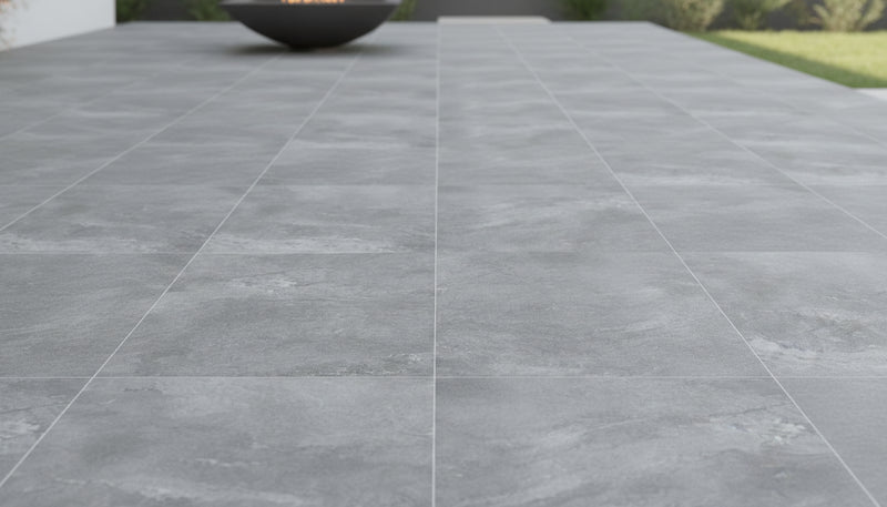 Close-up of Pluto Grey Porcelain Rough & Straight Edge 24 x 24 x 3/4 Paver, in Grey tones.