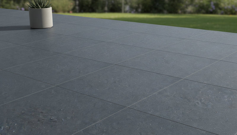 Close-up of Bluestone Dark Grey Porcelain Rough & Straight Edge 24 x 24 x 3/4 Paver, in Grey tones.