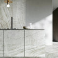 Montebello honed quartzite on a kitchen island and cabinetry with soft ivory and gray veining.
