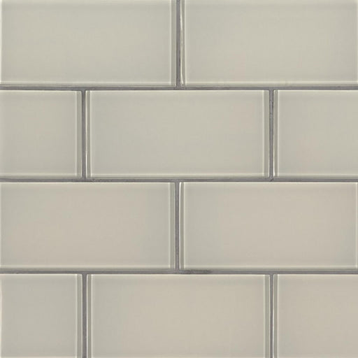 Snowcap White 3x6 glossy glass subway tiles in a staggered pattern with gray grout.