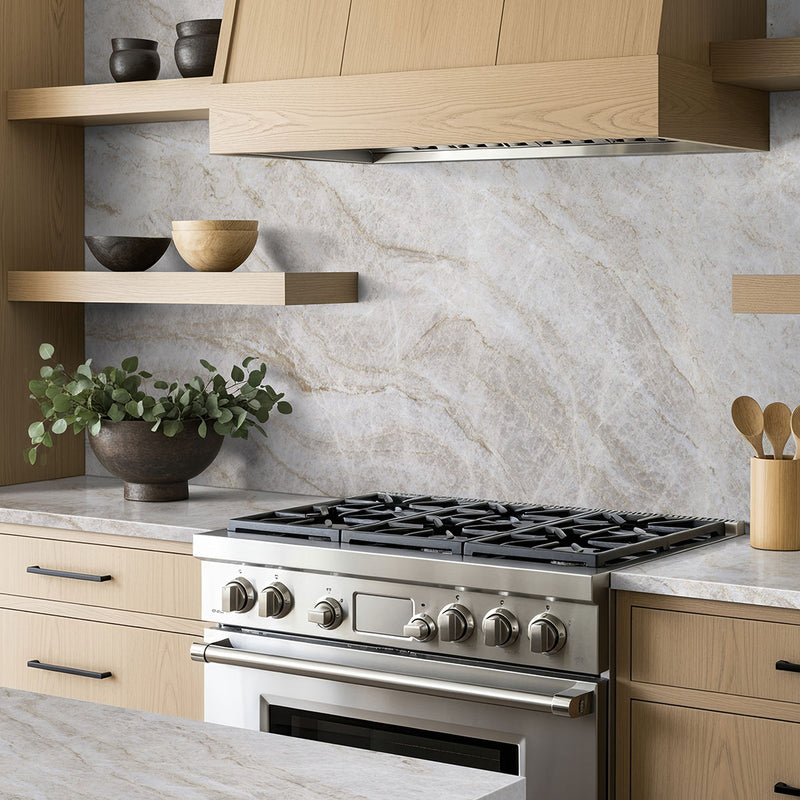 Taj Mahal quartzite backsplash and countertops in a kitchen with light wood cabinets.