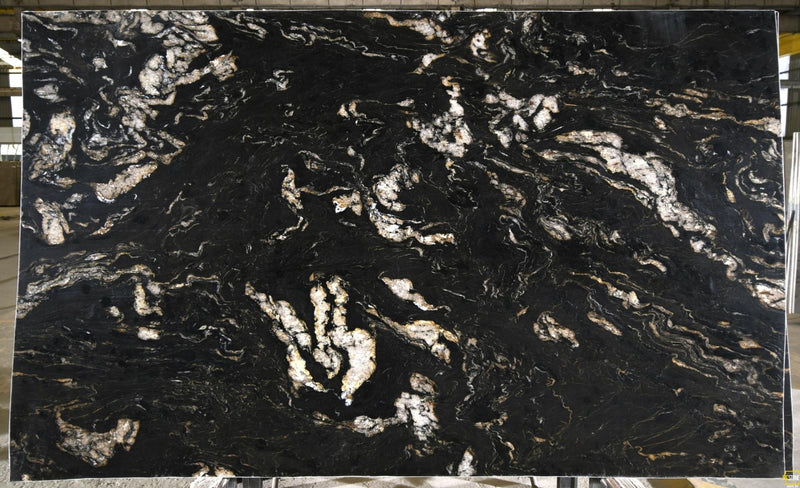 Titanium Gold 3cm leathered granite slab with a black background and flowing white, cream, and gold veining.